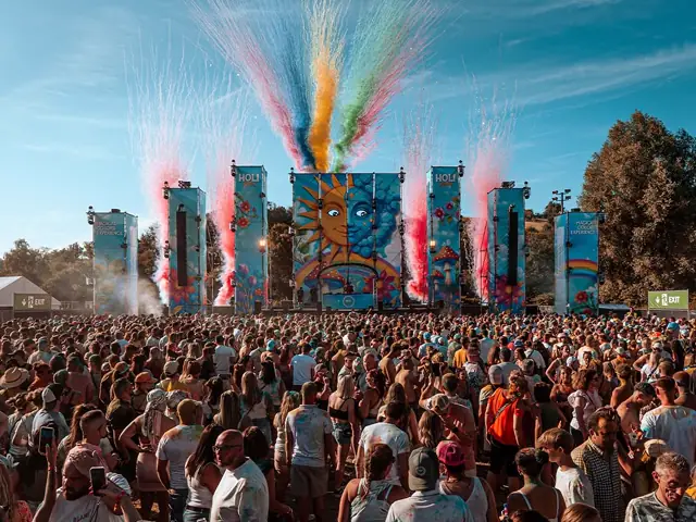 Jets de poudre multicolores projetés au-dessus de la foule depuis la scène